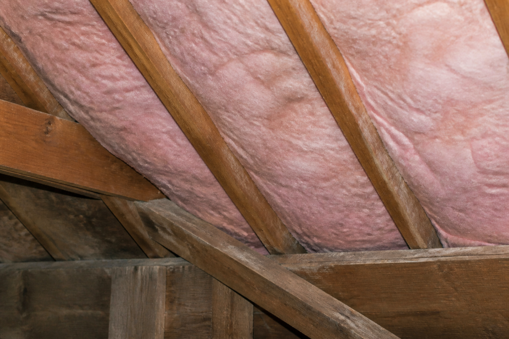 Fibre rose comprimee sous les chevrons en bois