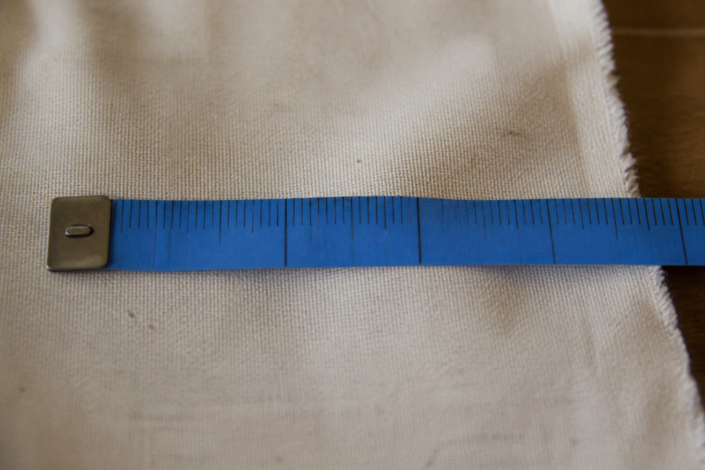 Ruban a mesurer bleu applique sur toile ecru
