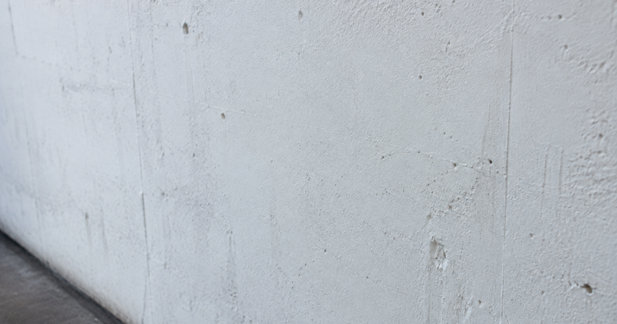 Mur vertical gris en beton recouvert de couche blanche